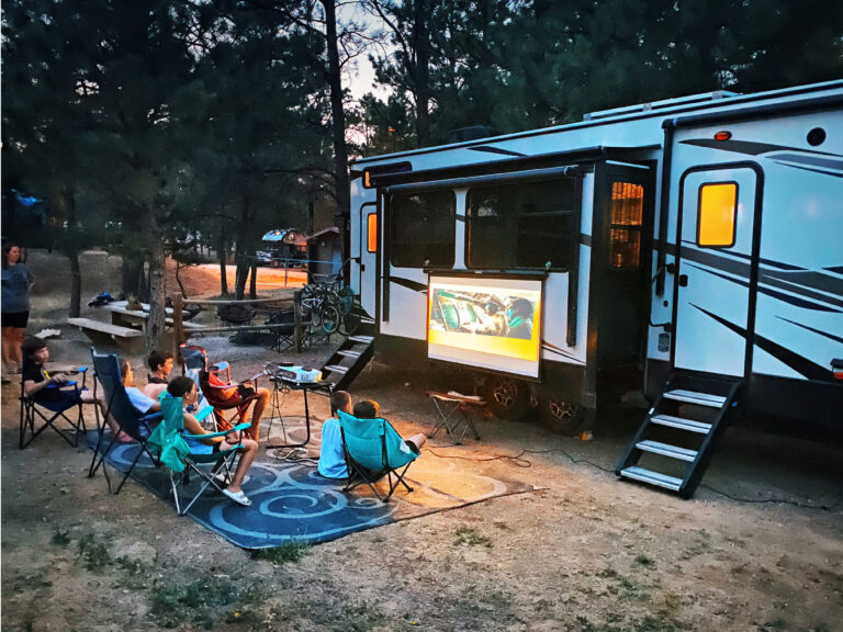 a family watching a movie outside their RV