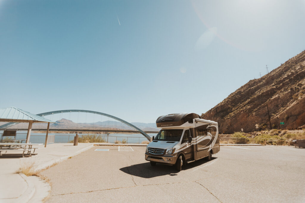 Class C camper parked near a reservoir