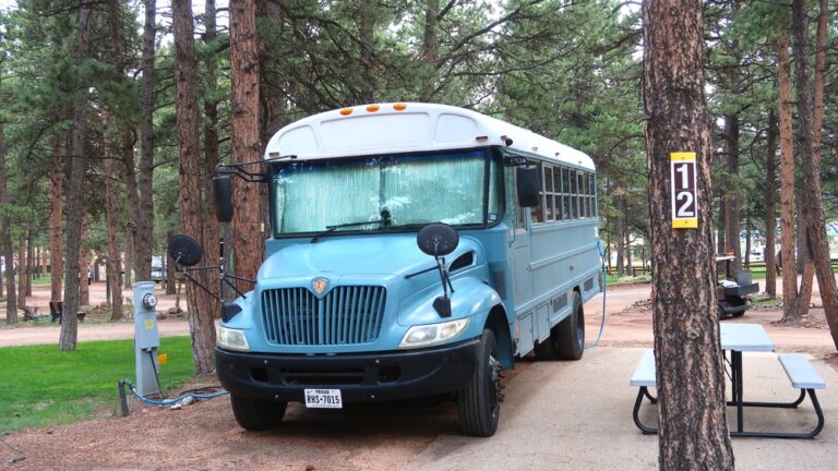 a blue school bus converted into a camper - Shutterstock