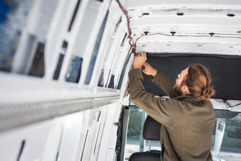 man working to convert his van - Shutterstock