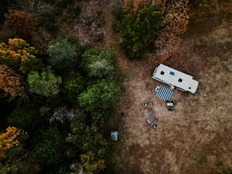 a birds-eye view of an RV parked among fall foliage