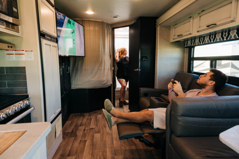 A man playing video games on an RV TV