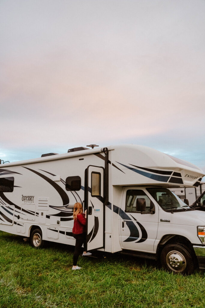 a Class C camper set up with a girl going in the door