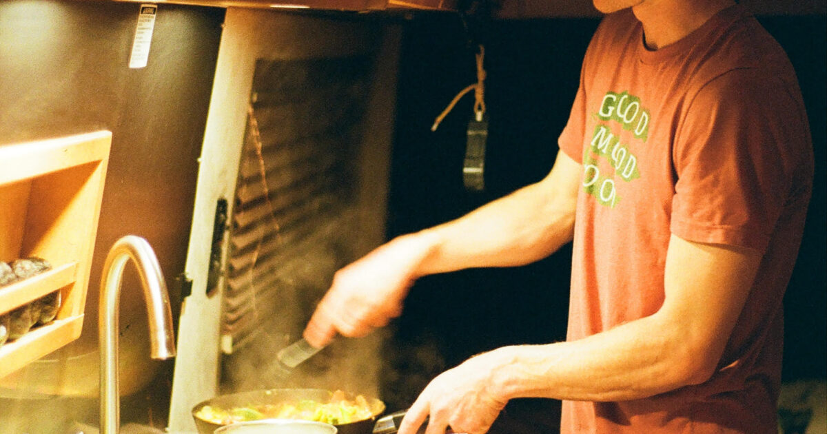 a man cooking on an RV stove