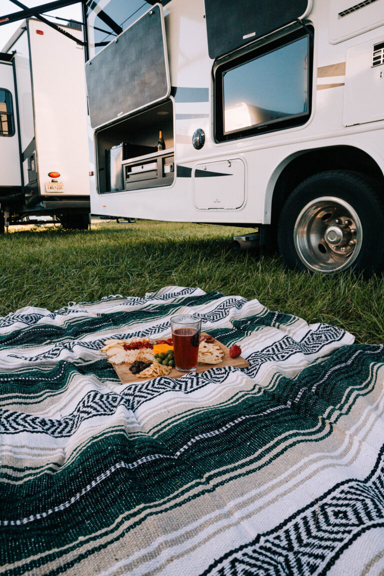 a meal on the grass in front of an RV tire