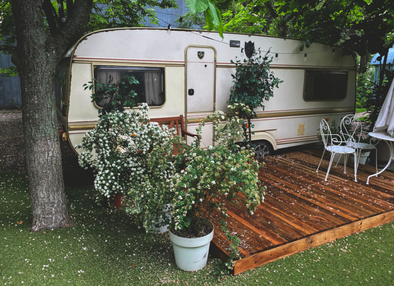 a vintage RV with flowers in front