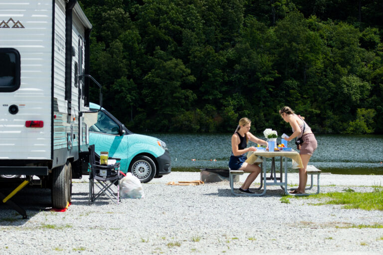 a picnic table and RV at a campsite