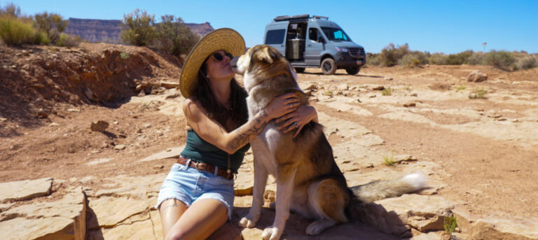 A woman and her dog in front of a Class B RV