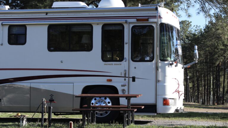 RV motorhome sitting next to a bench