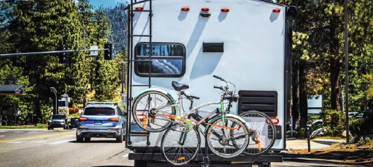 An RV with an RV bike rack and two bikes on the back