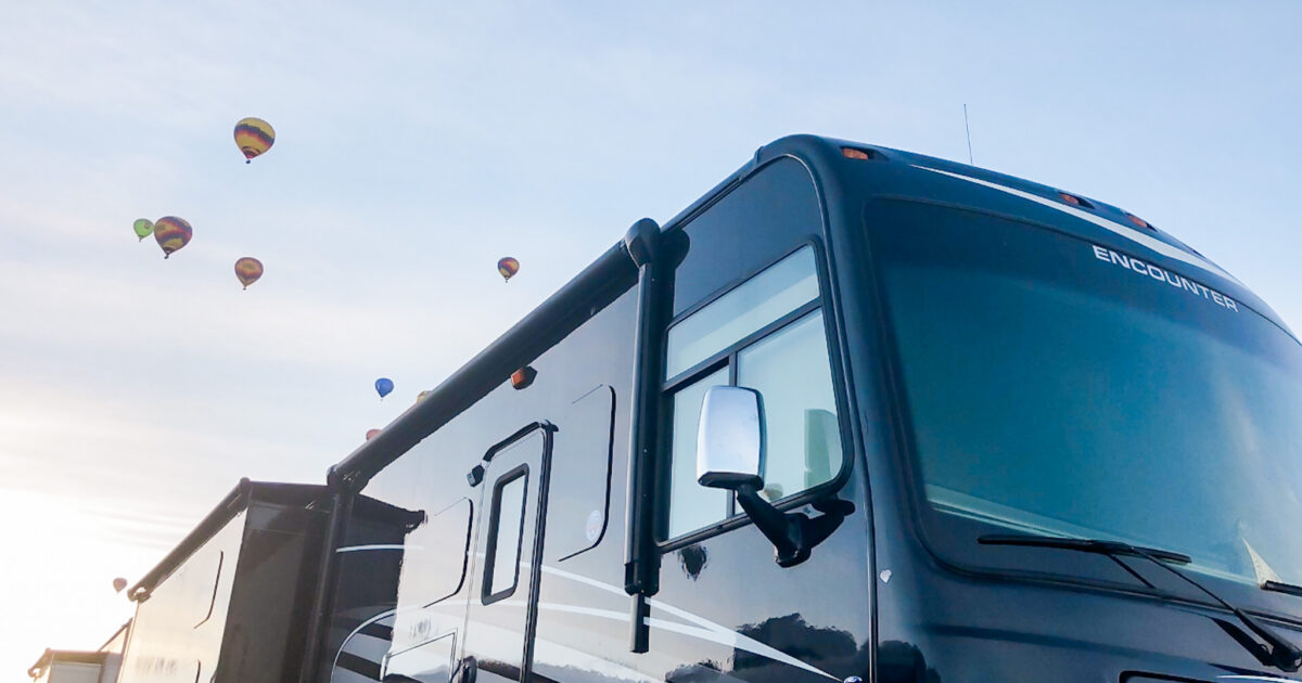 a Class A RV with hot air balloons behind