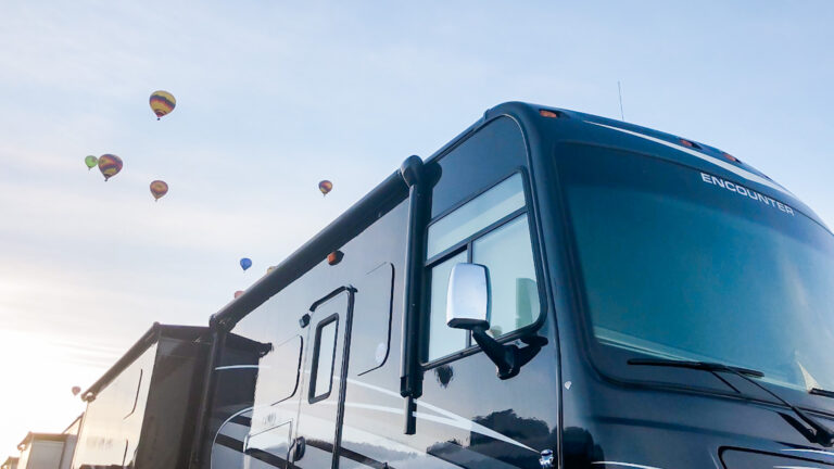 a Class A RV with hot air balloons behind