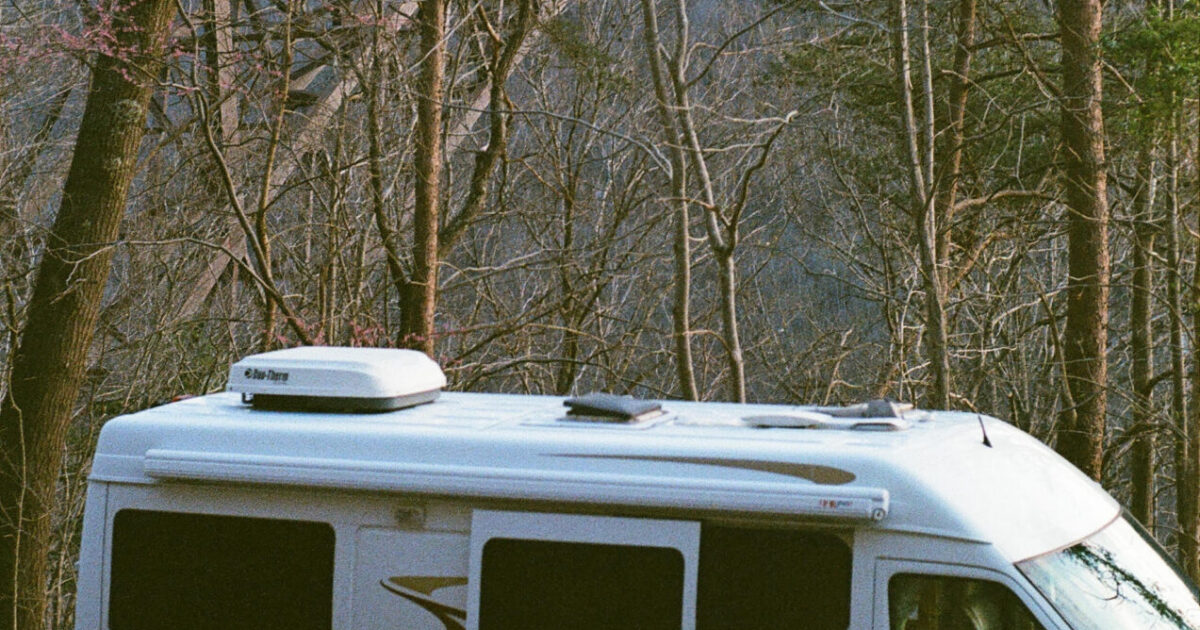 a Class B camper under a bridge