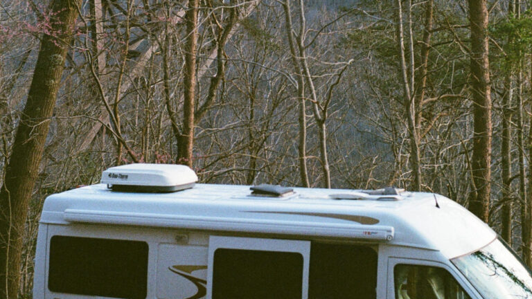 a Class B camper under a bridge