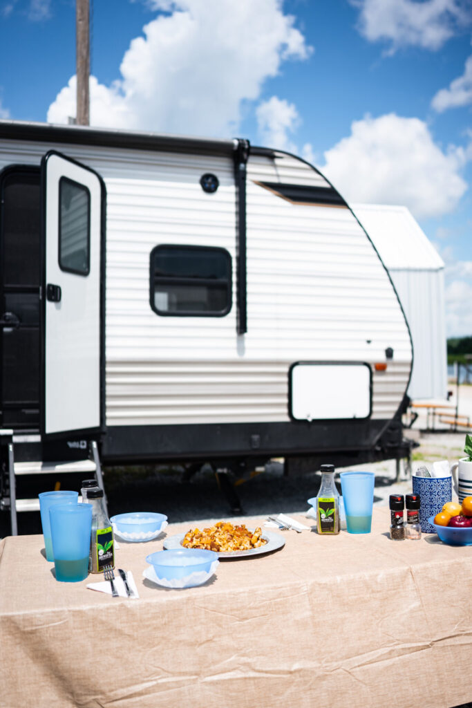 a trailer with food and drinks set up at a picnic table in front