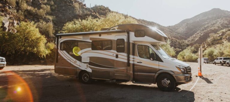 an RV parked on a road trip through a desert mountain landscape