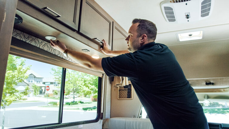 a man opening an RV cupboard