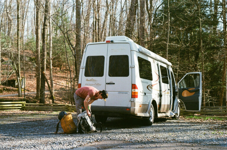 a man with his pack behind a campervan