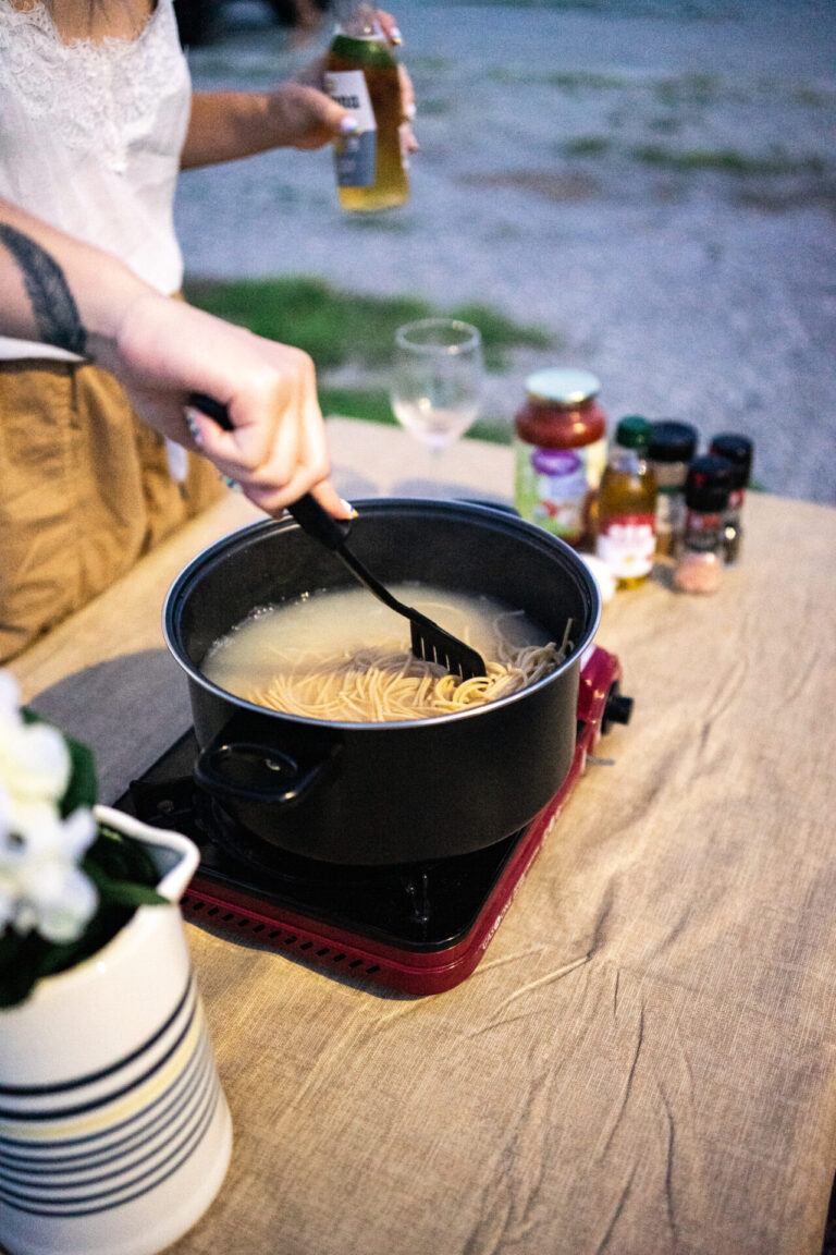 cooking pasta on a picnic table