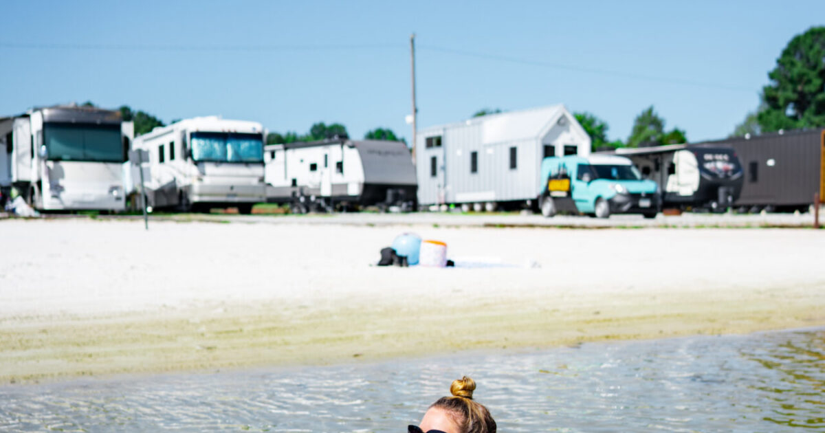 woman in an innertube in river in front of RV