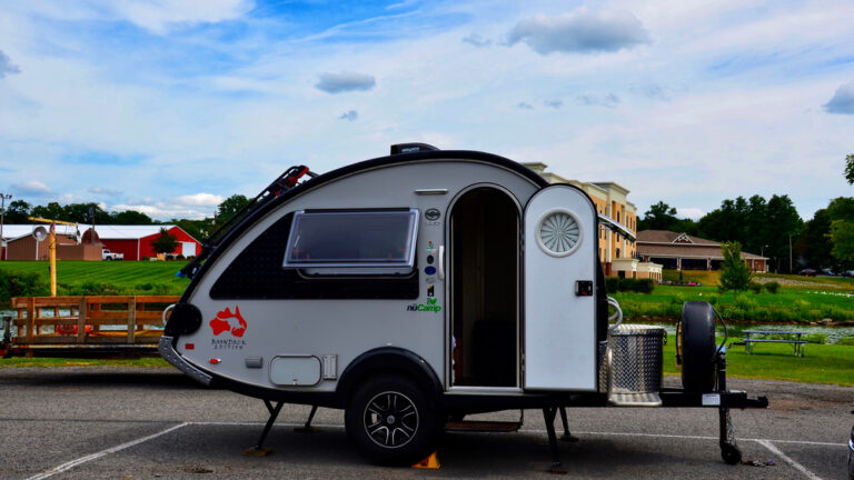 A teardrop camper set up in a parking lot