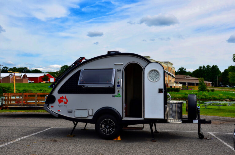 A teardrop camper set up in a parking lot