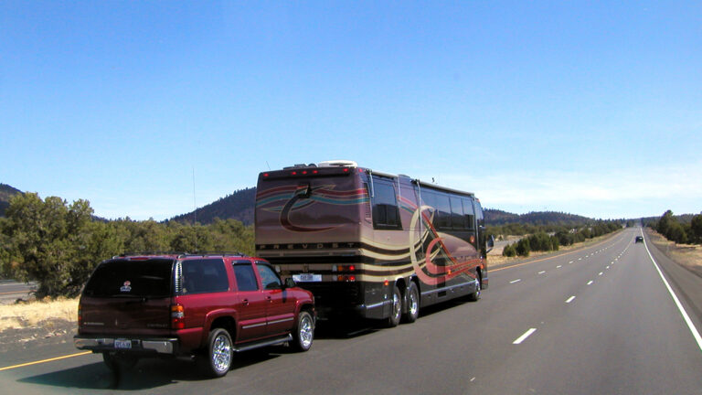 A Class A RV towing a car on a highway