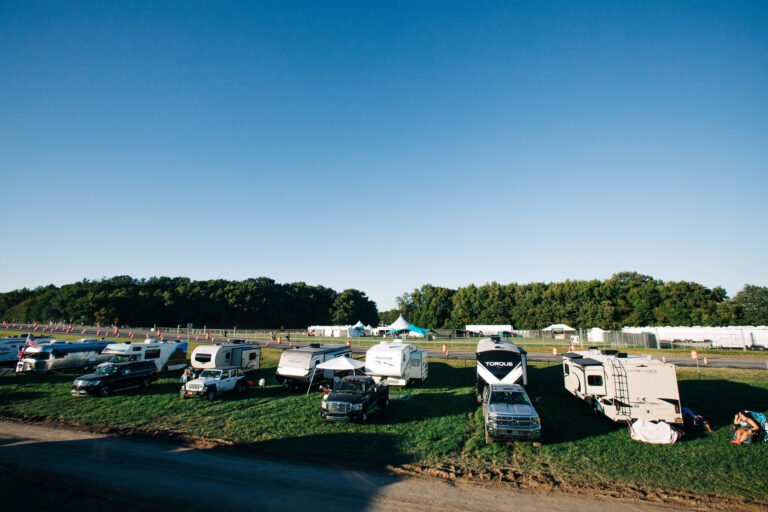 a group of RVs at a campground for a music festival