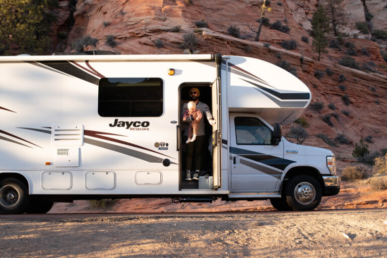 A man and baby in the doorway of a camper