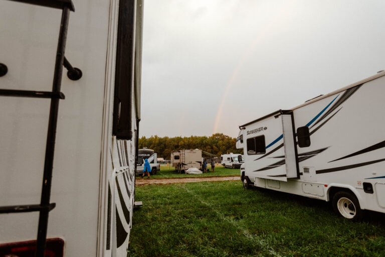 An RV parked at a campground with slideouts open