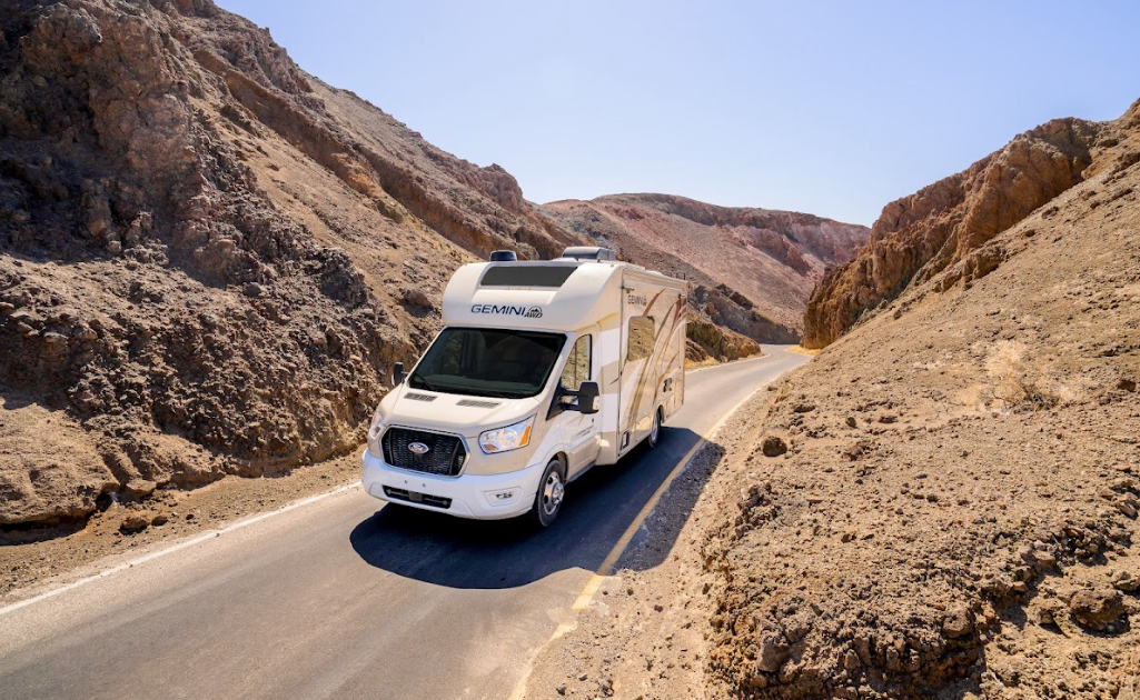 An RV camper on a one-lane rocky road