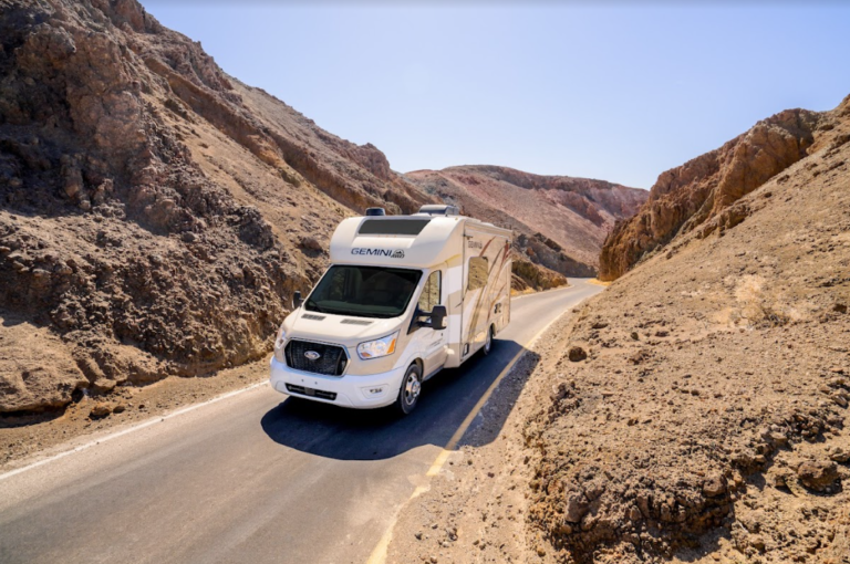 An RV camper on a one-lane rocky road