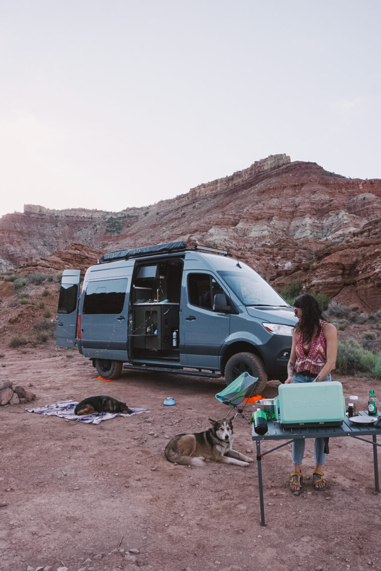 A woman cooking in front of her campervan