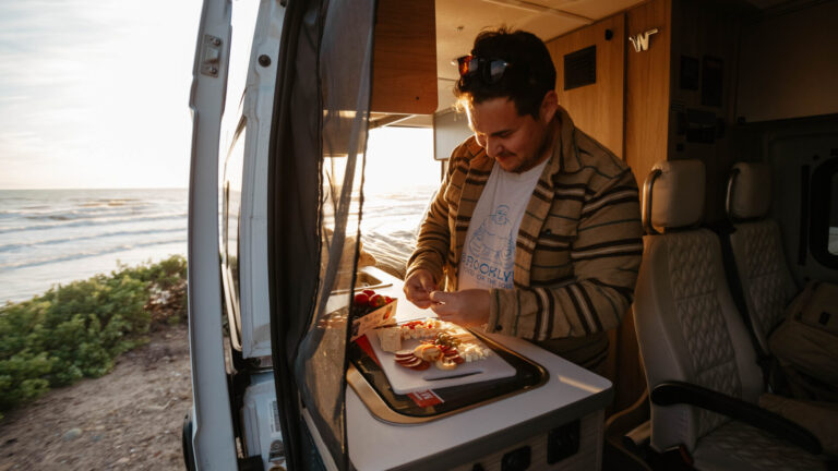 man in an RV cooking a meal