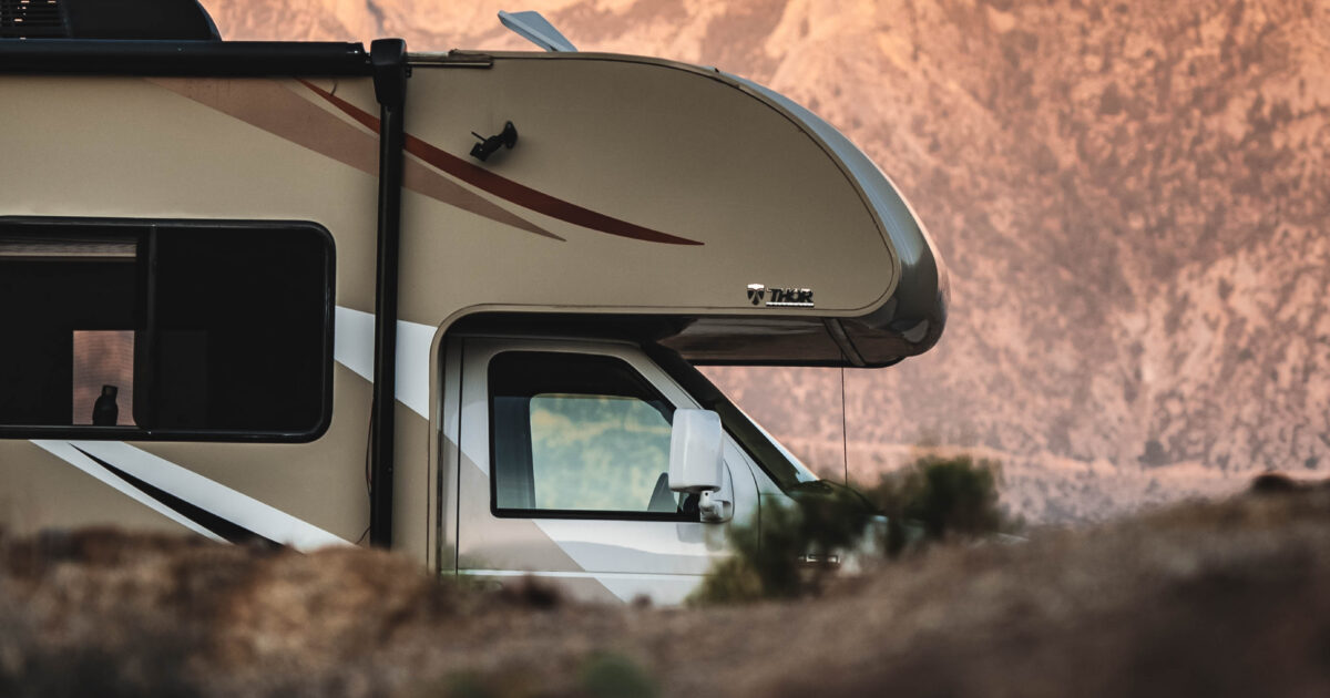 An RV parked in front of red rocks
