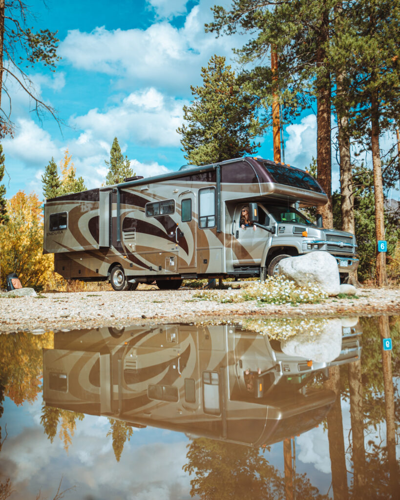 An RV parked and set up at a campground