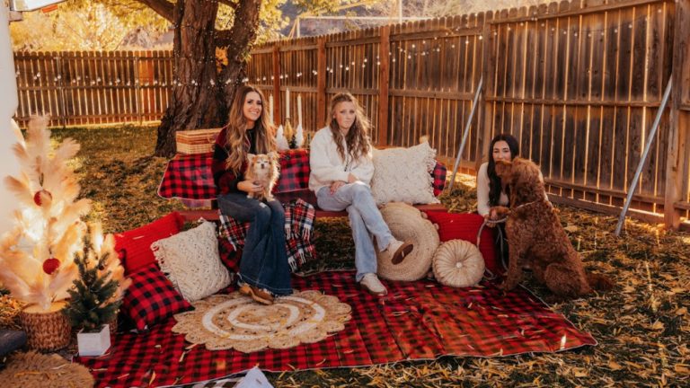 women sitting in a decorated space outside an RV