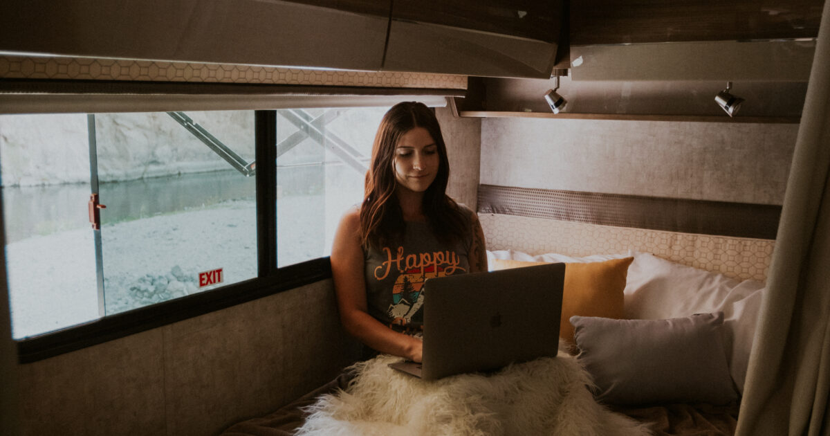 a woman on a laptop inside an RV