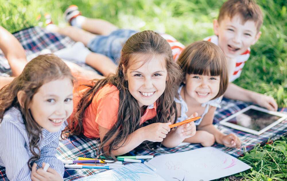 kids laying on the grass doing crafts