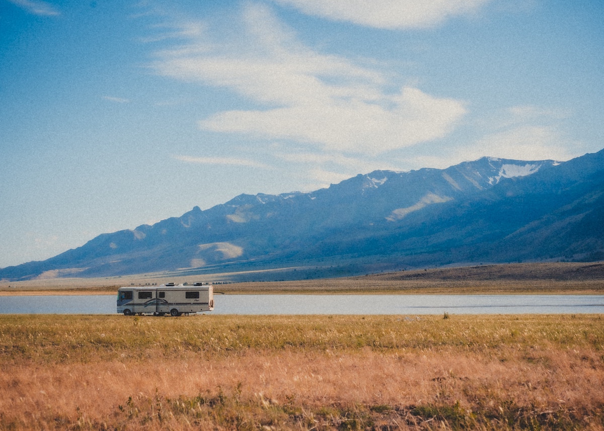 view of mountains with RV parked next to water