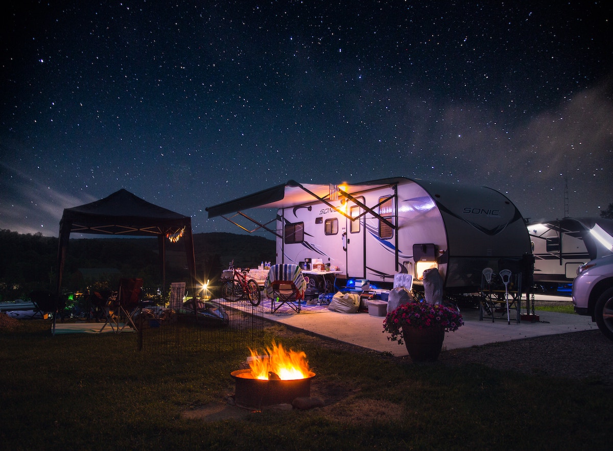 camp set up around trailer with fire pit at night