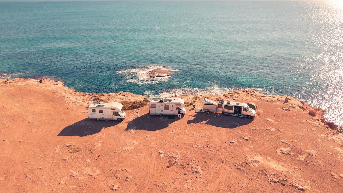 aerial view of 3 RVs parked by water