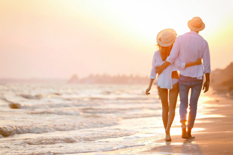 A couple walking into the sunset on the beach