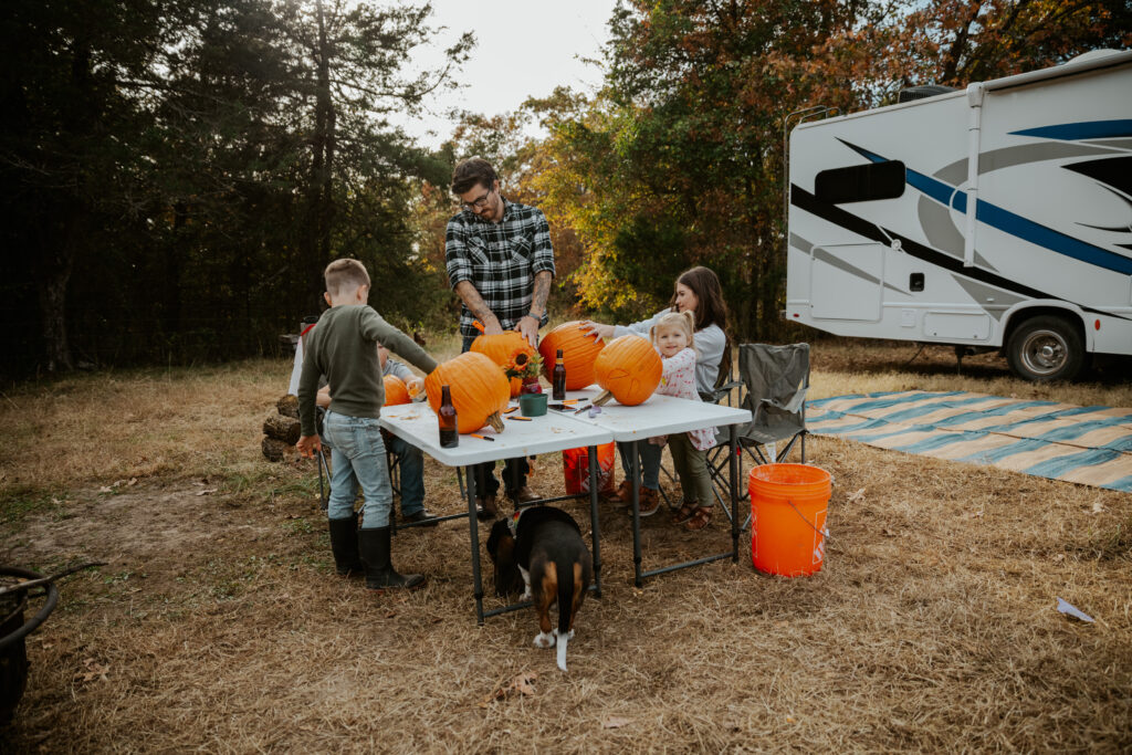 a family in an rv trip decorating pumpkins as a fall activity