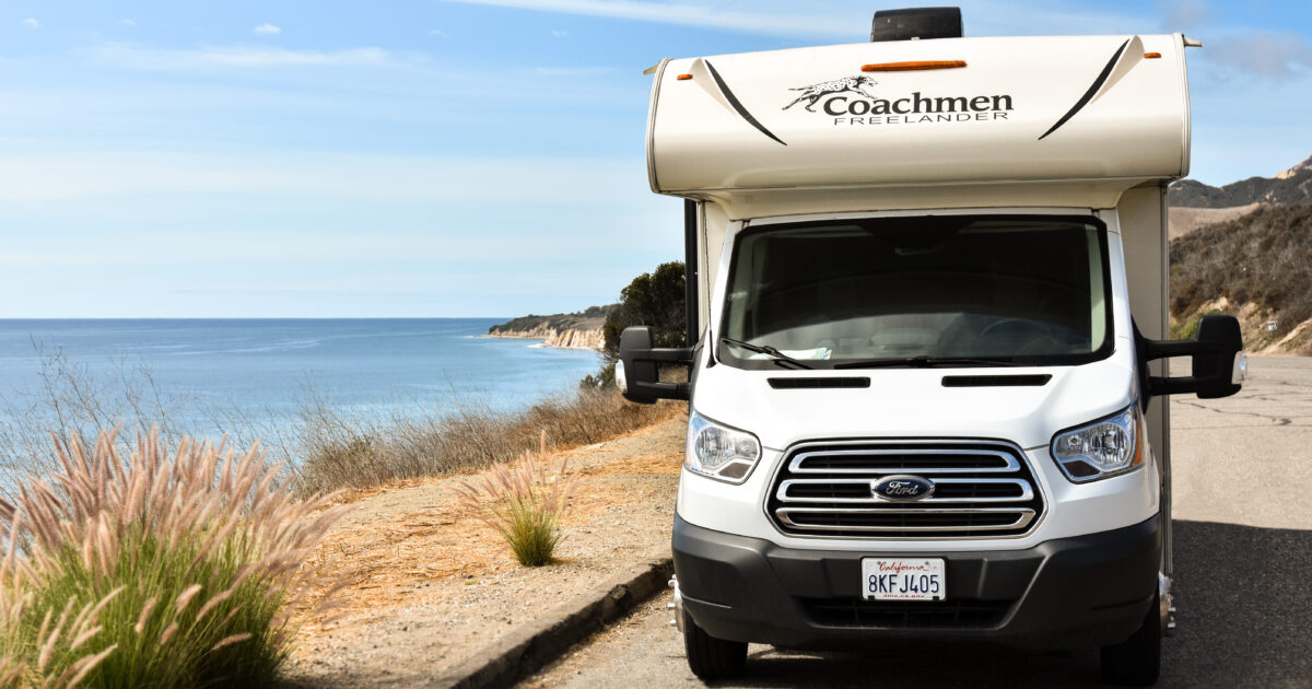 An RV parked next to the ocean