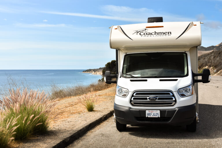 An RV parked next to the ocean