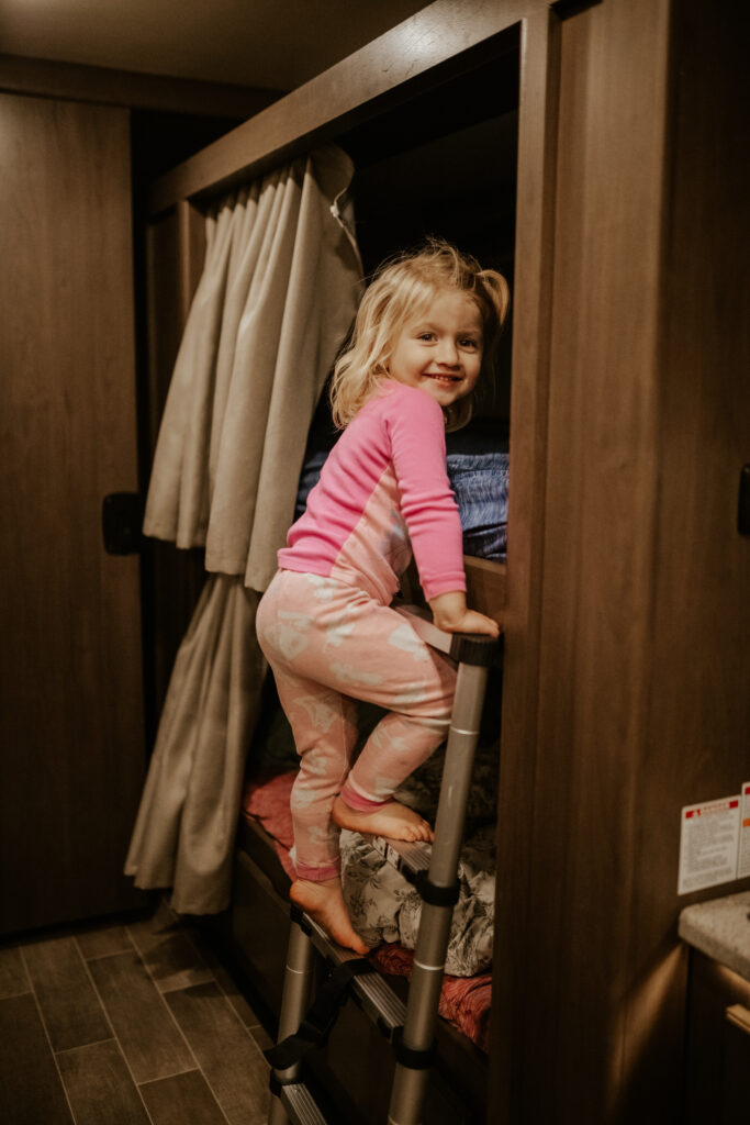 A kid climbing into an RV bunk