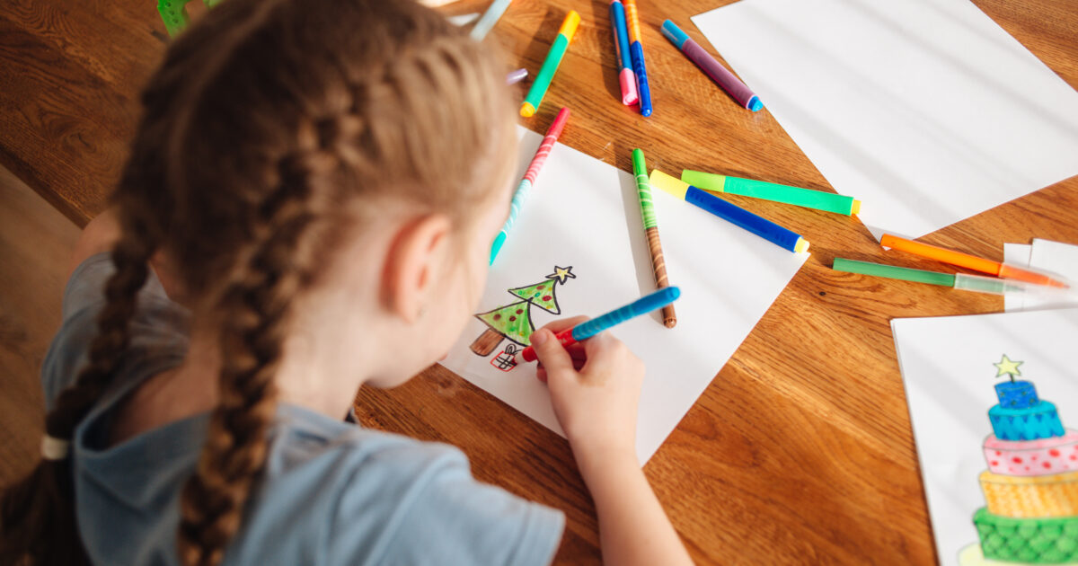 little girl drawing a christmas tree