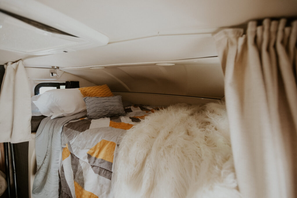 A bed with a furry coverlet and cozy blankets