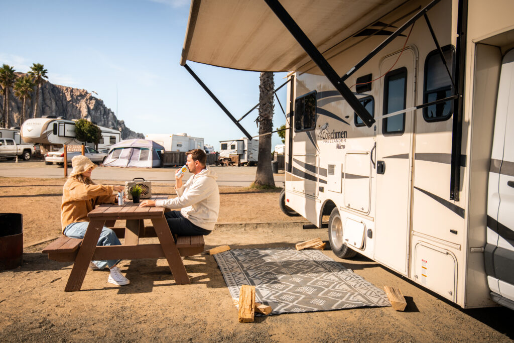 A couple picnicking next to their RV